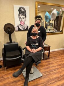 client having hair done in salon chair