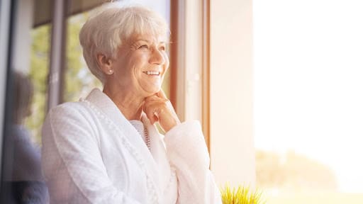 senior lady smiling to the distant sunrise
