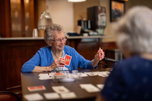 senior lady playing card game in cafe