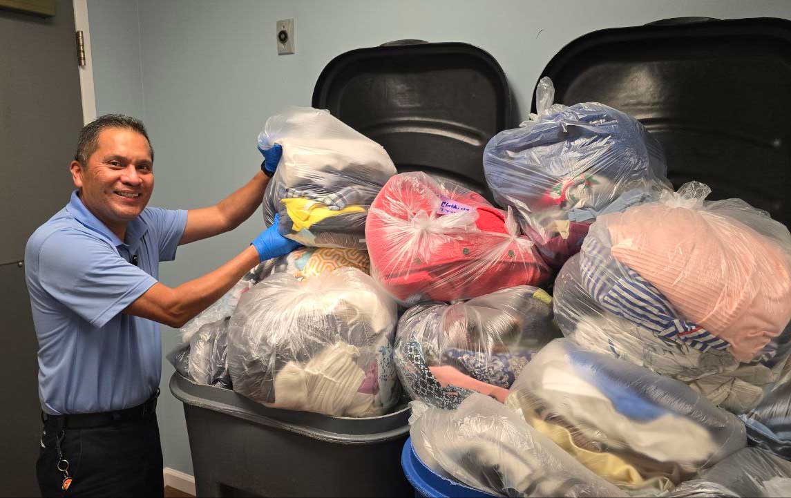 StoneRidge team member holding bags of clothes for First Clothing Drive 
