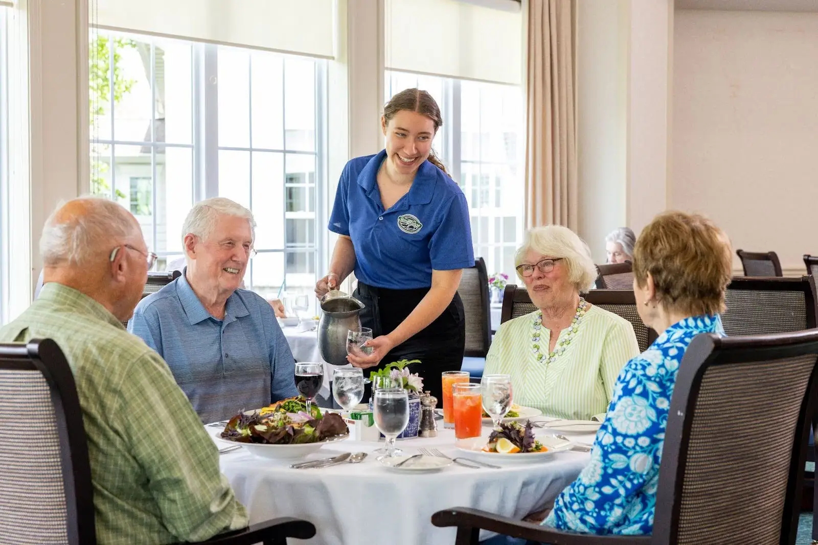 Two senior couples enjoying meal in the StoneRidge dining room