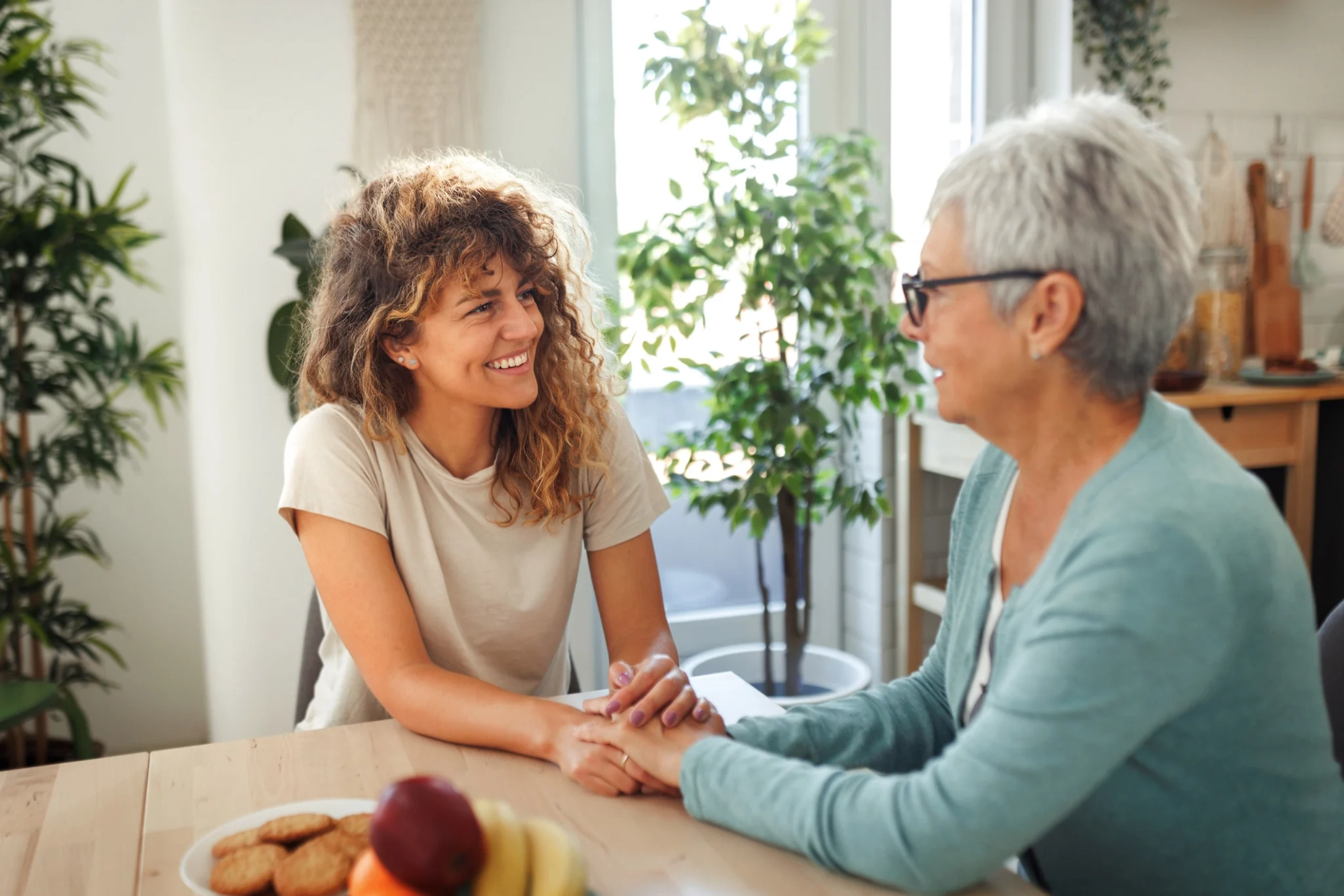 iStock-1610586080 An adult woman holding her mother's hands while discussing how to find help for her aging parents and talking about independent living options at StoneRidge In Mystic, CT.