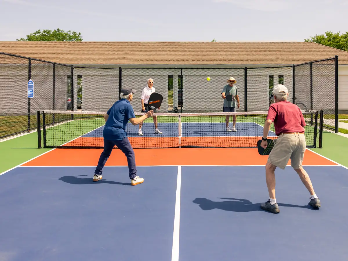 4 senior men playing pickle ball at StoneRidge, a senior living community in CT.