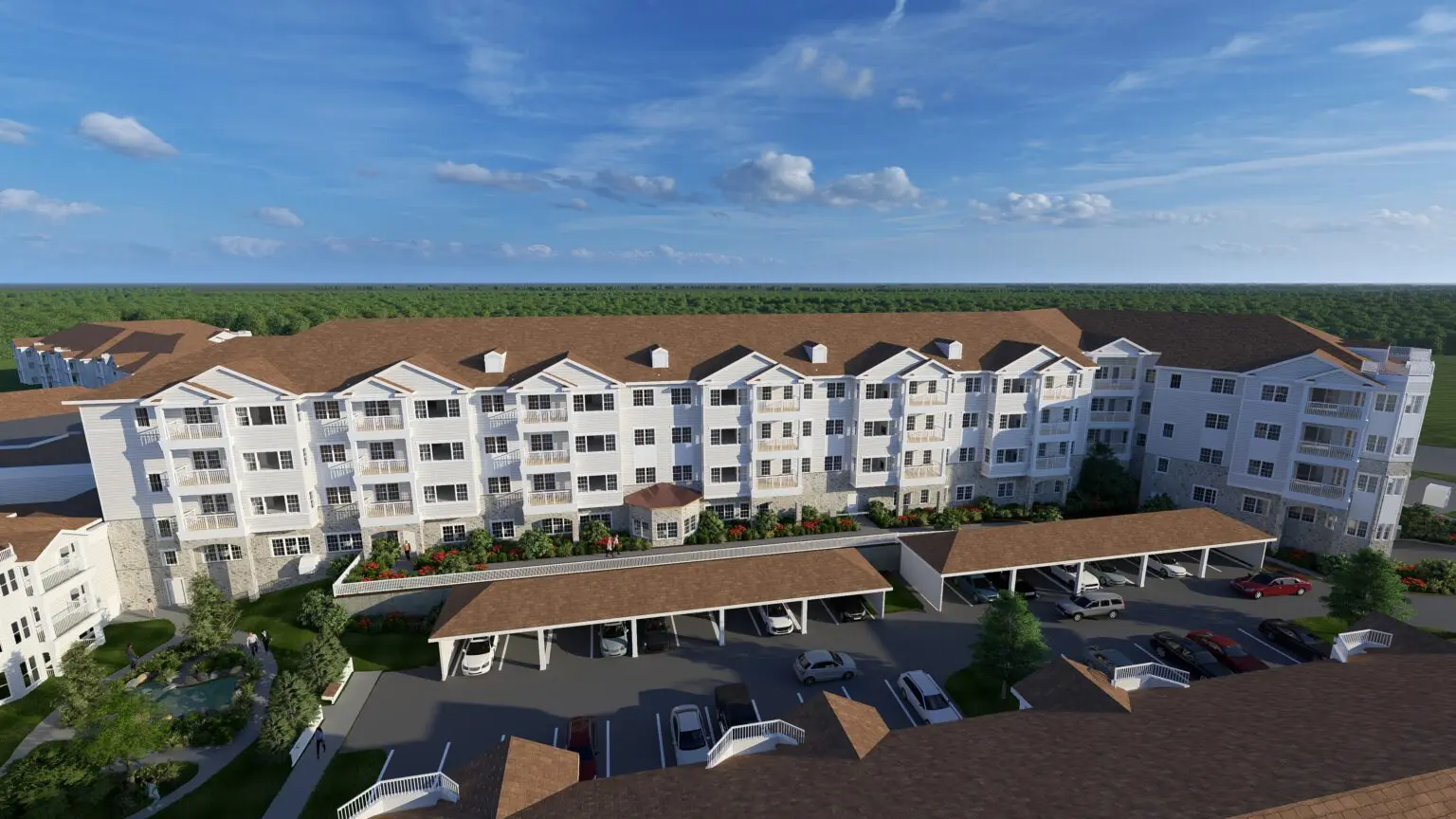 An aerial view of the West Elevation showcasing growth at StoneRidge in Mystic, CT. The image features a large white building with a brown roof for senior housing with other building and tree.