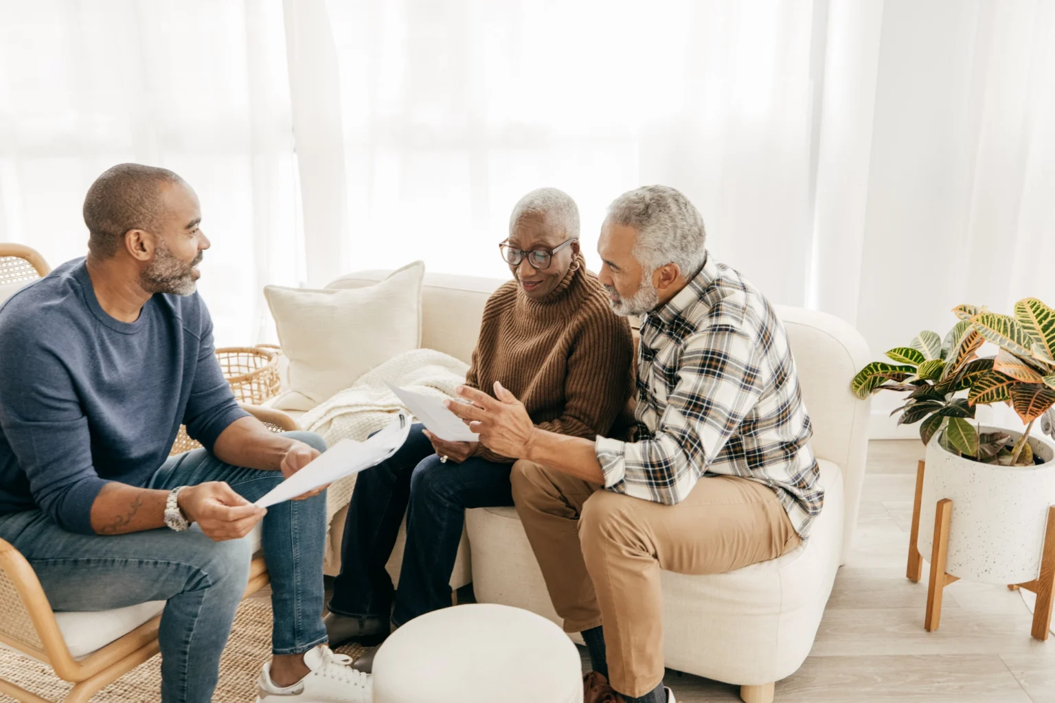 An adult son discussing independent living options with his aging parents at StoneRidge in Mystic, CT.
